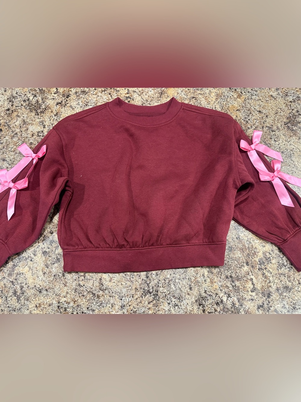 Burgundy sweatshirt with pink bows on sleeves